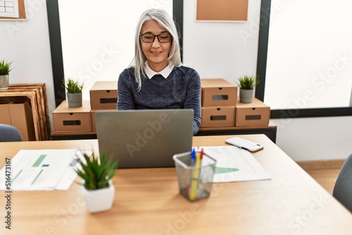 Middle age grey-haired woman business worker using laptop working at office