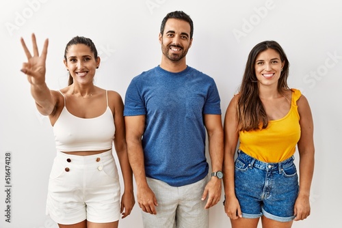 Group of young hispanic people standing over isolated background showing and pointing up with fingers number three while smiling confident and happy.