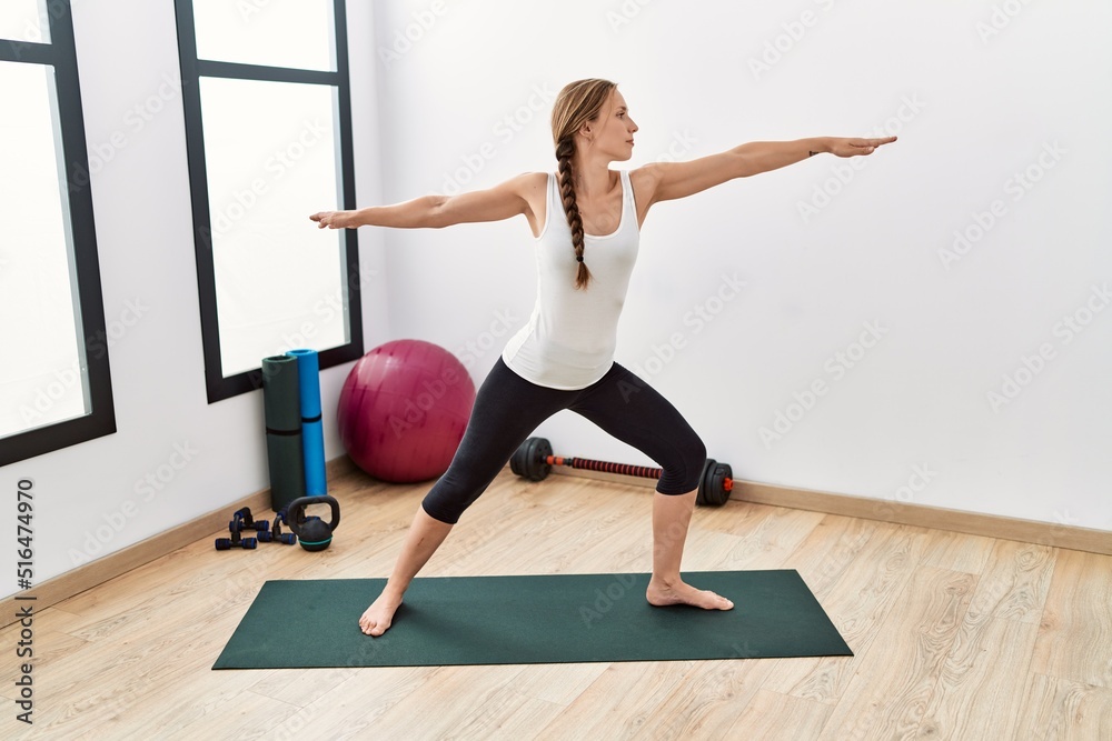 Young caucasian woman training yoga at sport center