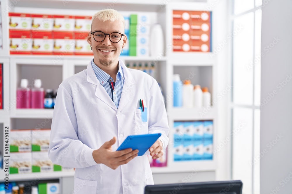 Young caucasian man pharmacist using touchpad working at pharmacy Young caucasian man pharmacist using touchpad working at pharmacy