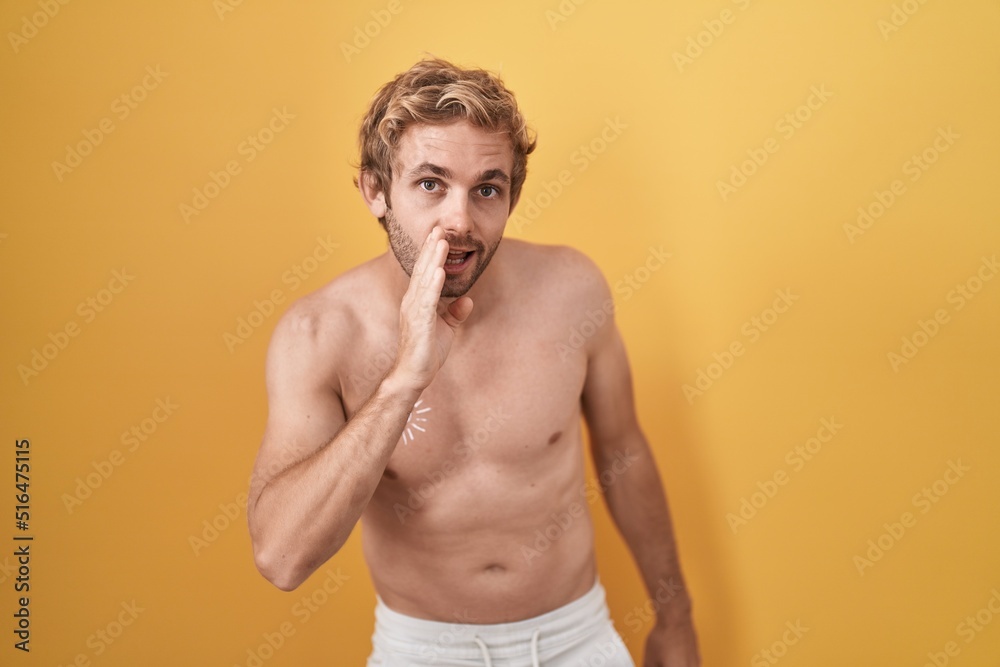 Caucasian man standing shirtless wearing sun screen hand on mouth telling secret rumor, whispering malicious talk conversation