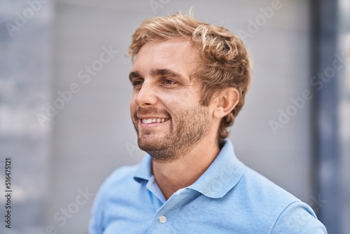 Young man smiling confident looking to the side at street