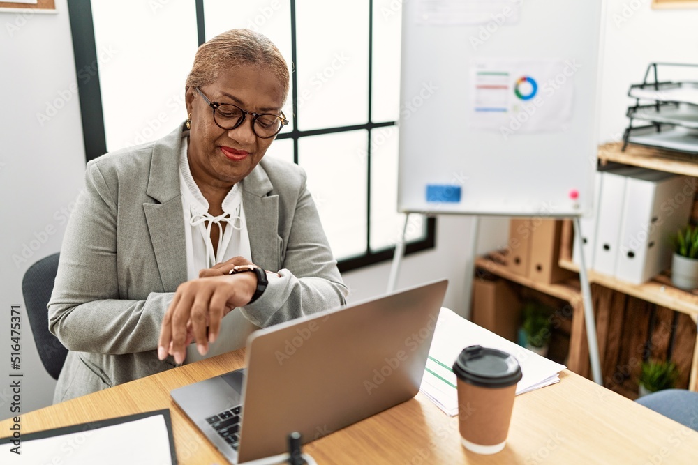 Senior african american woman business worker looking watch at office Senior african american woman business worker looking watch at office