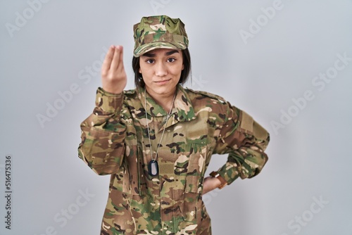 Young south asian woman wearing camouflage army uniform doing italian gesture with hand and fingers confident expression photo