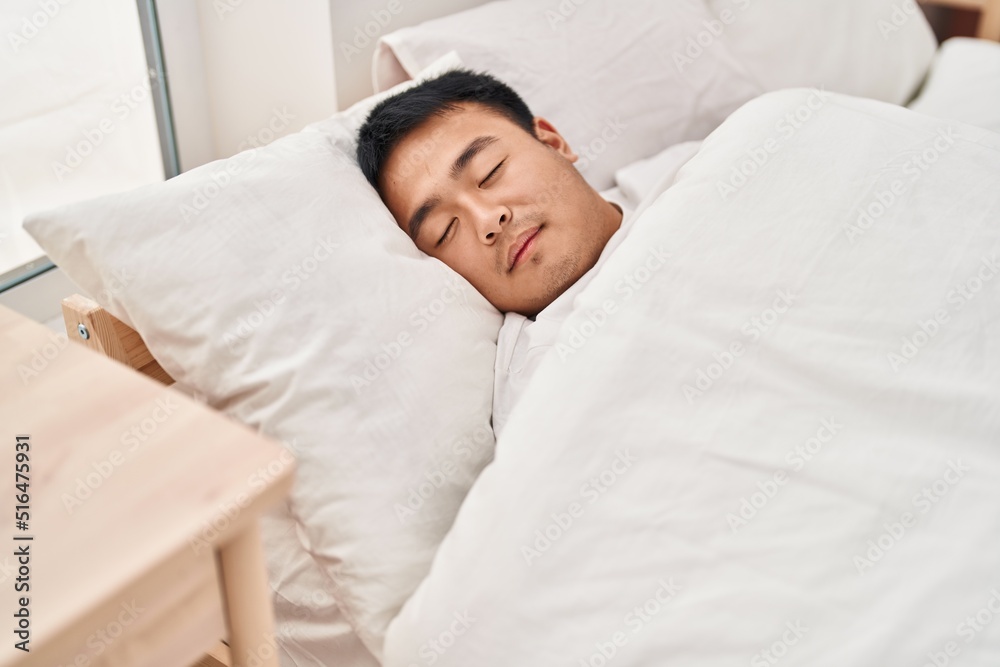 Young chinese man lying on bed sleeping at bedroom Young chinese man lying on bed sleeping at bedroom