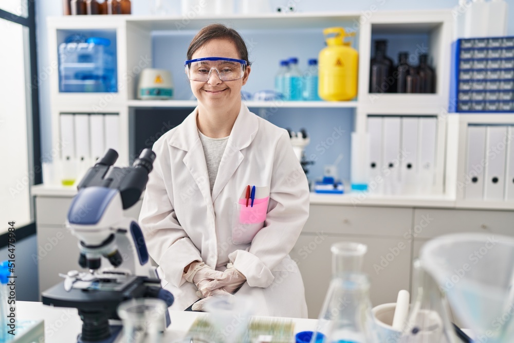 Hispanic girl with down syndrome working at scientist laboratory with a happy and cool smile on face. lucky person. Hispanic girl with down syndrome working at scientist laboratory with a happy and cool smile on face. lucky person.