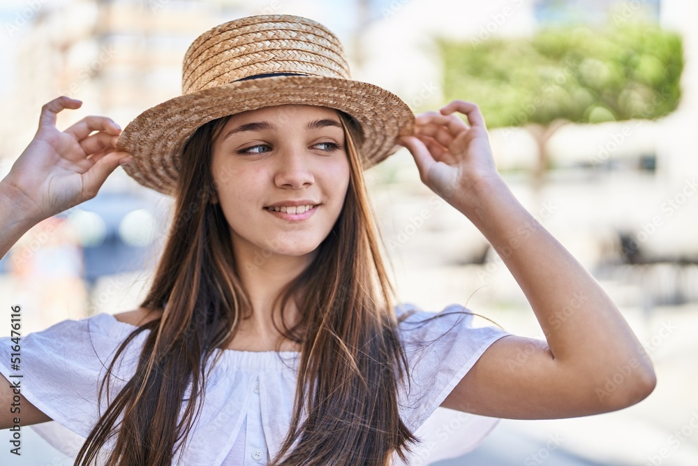 Adorable girl tourist smiling confident wearing summer hat at street