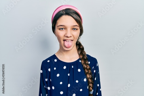 Obraz na plátně Young brunette girl wearing elegant look sticking tongue out happy with funny expression