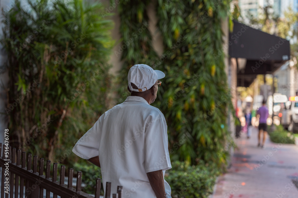 person walking in the city old men black white hat miami 