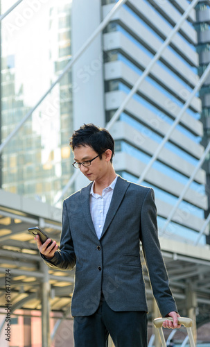 Business Man hands holding mobile phone outdoor surfing internet online technology lifestyle in city street. Entrepreneur young man in business suit hand using smartphone gadget text message lifestyle