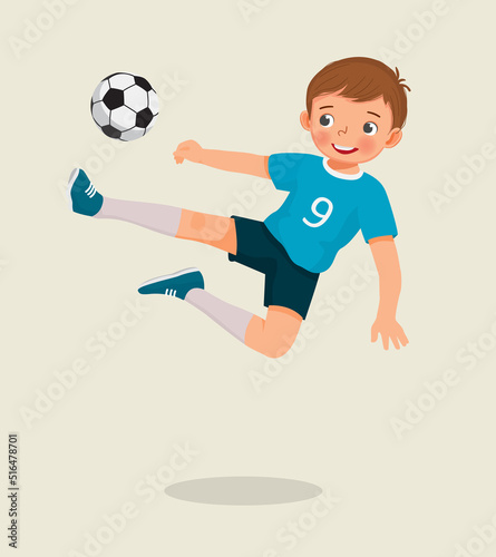 cute little boy playing soccer jumping high kicking the football to make a goal