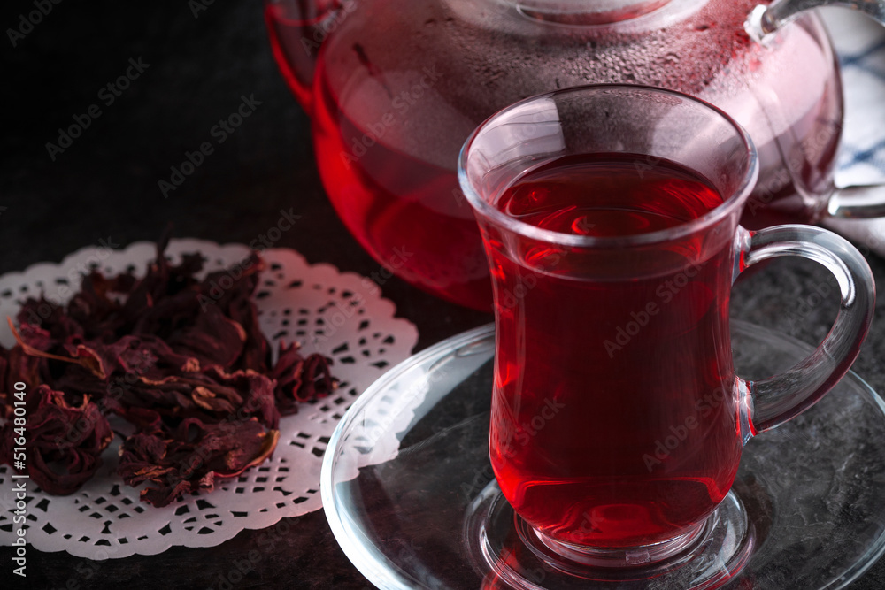 A teapot and a cup with healing tea. Dried Hibiscus flowers. A teapot and a cup with healing tea. Dried Hibiscus flowers.
