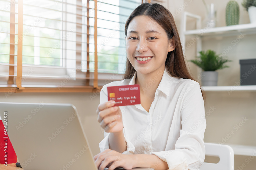 Internet banking, Online shopping at home, happy asian young woman, girl hand in holding credit card, using laptop computer, spending money with purchase, pay on store at home. Shopaholic e-commerce. Internet banking, Online shopping at home, happy asian young woman, girl hand in holding credit card, using laptop computer, spending money with purchase, pay on store at home. Shopaholic e-commerce.