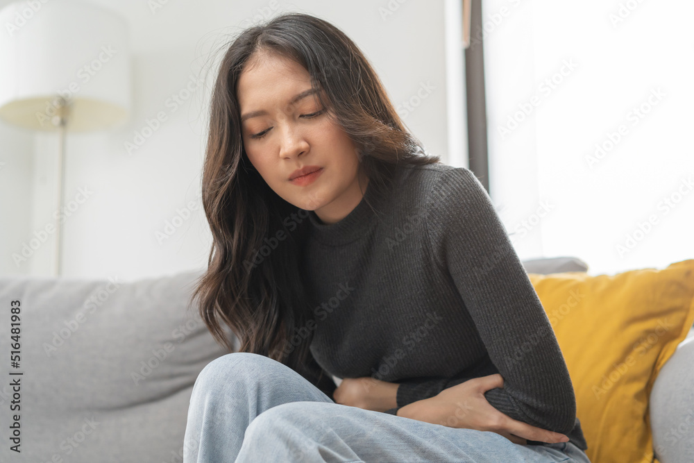 Flatulence asian young woman, girl hand in stomach ache, suffer from food poisoning, abdominal pain and colon problem, gastritis or diarrhoea. Patient belly, abdomen or inflammation, concept. Flatulence asian young woman, girl hand in stomach ache, suffer from food poisoning, abdominal pain and colon problem, gastritis or diarrhoea. Patient belly, abdomen or inflammation, concept.