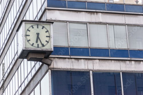 Clock on blue building with big windows.