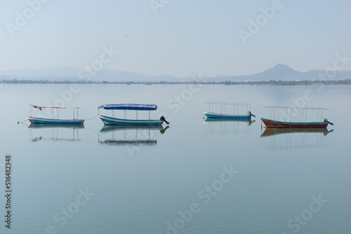Four boats floating in a lagoon of calm waters.