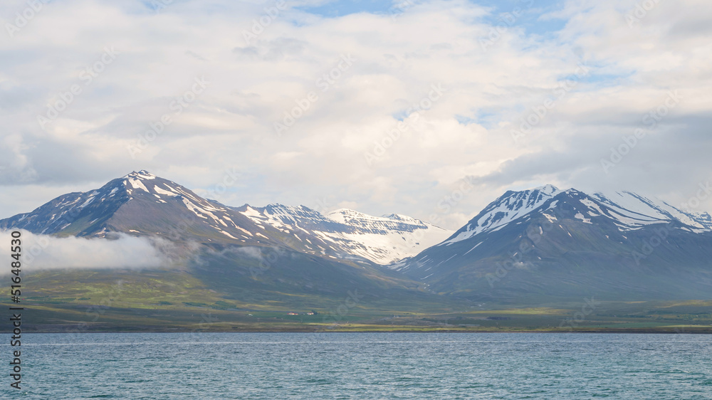 Icelandic panorama of mountains and ocean with snow on peak in the region of Akureyri