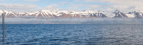 Icelandic panorama of mountains and ocean with snow on peak in the region of Akureyri