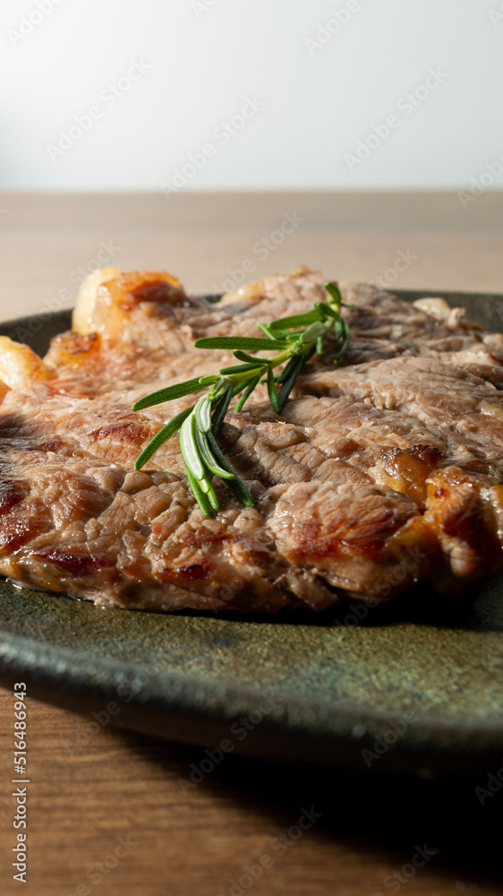 delicious roast beef, on a black plate and wooden surface, with a sprig of thyme on top delicious roast beef, on a black plate and wooden surface, with a sprig of thyme on top