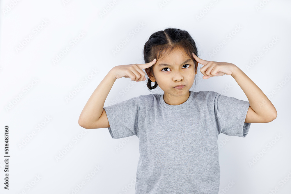 Portrait of angry little girl and both hands pointing at her head isolated on white background. Portrait of angry little girl and both hands pointing at her head isolated on white background.
