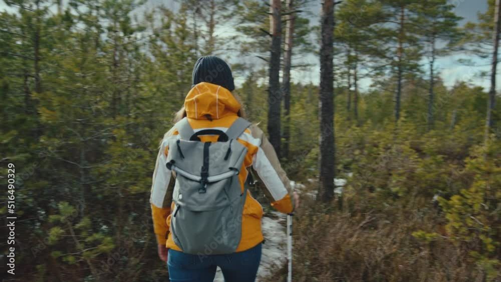 Caucasian woman walks into shot and continues through forest Caucasian woman walks into shot and continues through forest