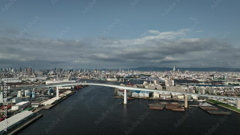 Slow move in towards light traffic on bridge at edge of sprawling city Slow move in towards light traffic on bridge at edge of sprawling city
