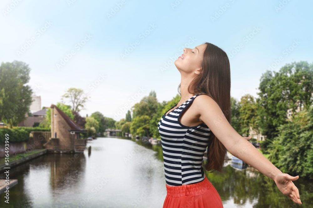 Happy woman stands on the viewpoint and enjoys the panorama of resort town