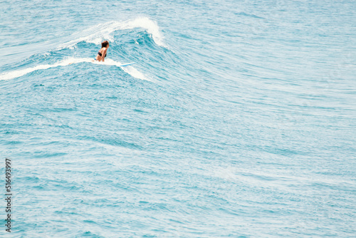 Surfer rookie girl in running chest over the surfboard on the wave crest photo