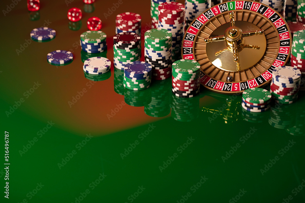 Casino. Gambling games theme. Roulette wheel, dice and poker chips on the casino felt green table. Casino. Gambling games theme. Roulette wheel, dice and poker chips on the casino felt green table.