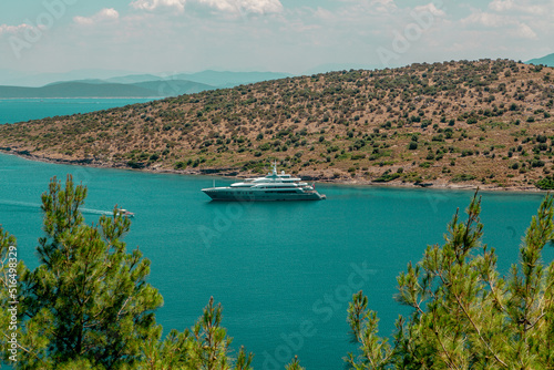 Luxury yacht above the sea.Green forest and clear sky.Beautiful view Turkey Bodrum Turkbuku bay. photo