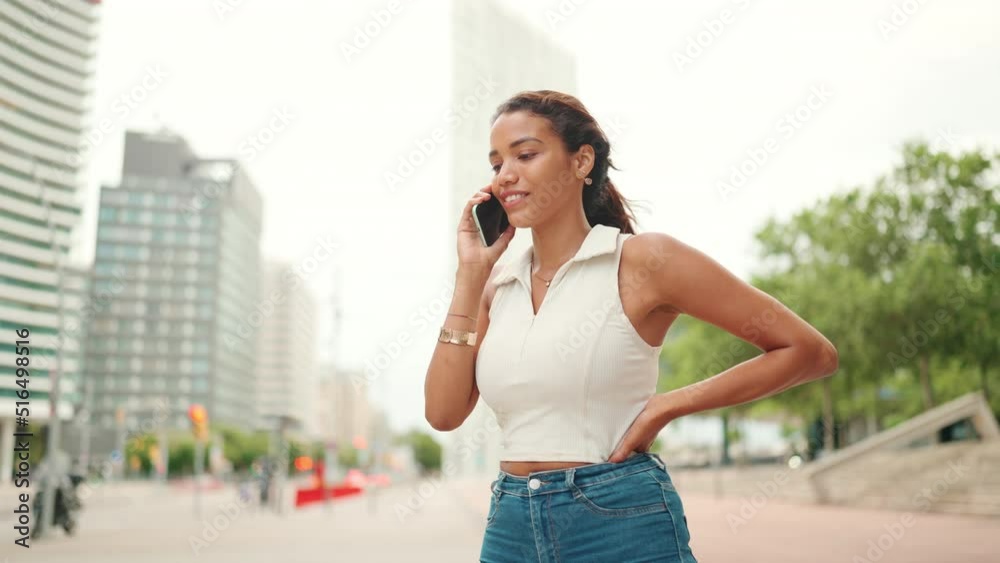 Lovely tanned woman with ponytail wearing white top is using mobile phone. Girl talking on smartphone on city landscape background Lovely tanned woman with ponytail wearing white top is using mobile phone. Girl talking on smartphone on city landscape background