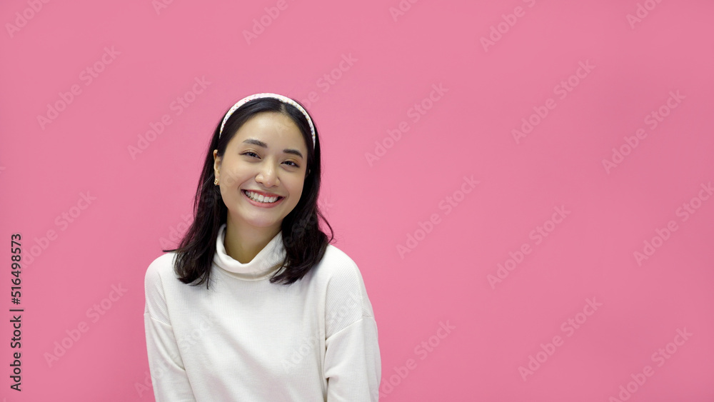 Fototapeta premium happy young woman Asian smiling and having good time, laughing, looking to side on pink background