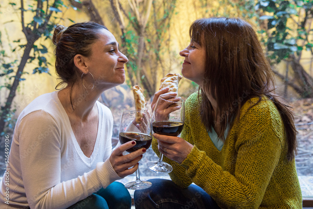 Happy LGBTQ couple eating empanadas and drinking a glass of wine sharing a leisure time at home. Dating, relationship concept.
Happy LGBTQ couple eating empanadas and drinking a glass of wine sharing a leisure time at home. Dating, relationship concept.