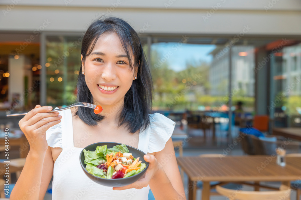 Woman eating Breakfast and play smart phone. Fruits such as watermelon, papaya, melon, passion fruit, orange juice and coffee. placed on a gray placemat Woman eating Breakfast and play smart phone. Fruits such as watermelon, papaya, melon, passion fruit, orange juice and coffee. placed on a gray placemat