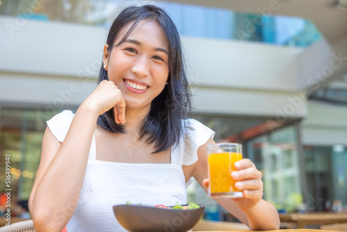 Woman eating Breakfast. Fruits such as watermelon, papaya, melon, passion fruit, orange juice and coffee. placed on a gray placemat