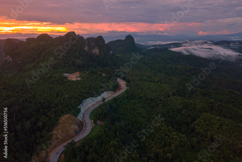 Aerial view of unseen sky road on the mountains forest during the dusk with clouds over the mountain. Route 12 (AH1) Tak - Mae Sot, an amazing road in Thailand. photo