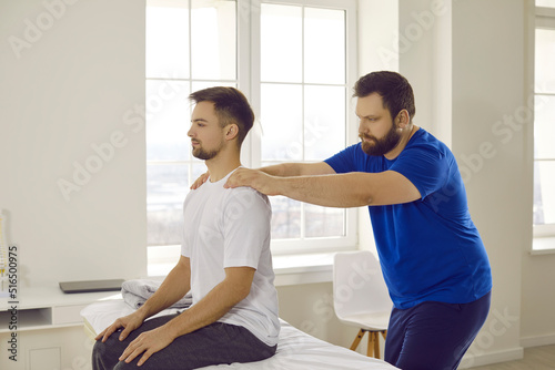 Masseur work with patient having back pain relieve strain in muscles. Male physiotherapist procedures with client in medical clinic. Injury recovery or rehabilitation. Healthcare concept.
