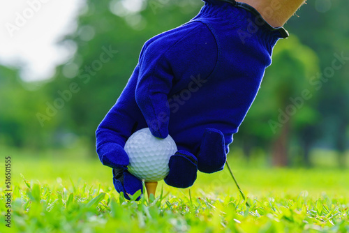 Hand Golfer hold Golf ball with tee ready to be shot at golf court