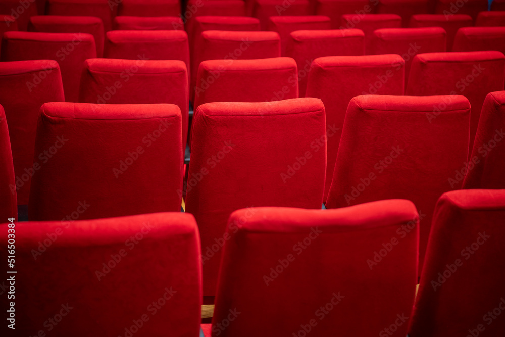 Obraz premium Cinema movie theater background. Red cozy cinema seats in empty theater. Armchairs with comfortable elbows.