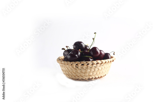 a bowl of black cherry isolated on white background