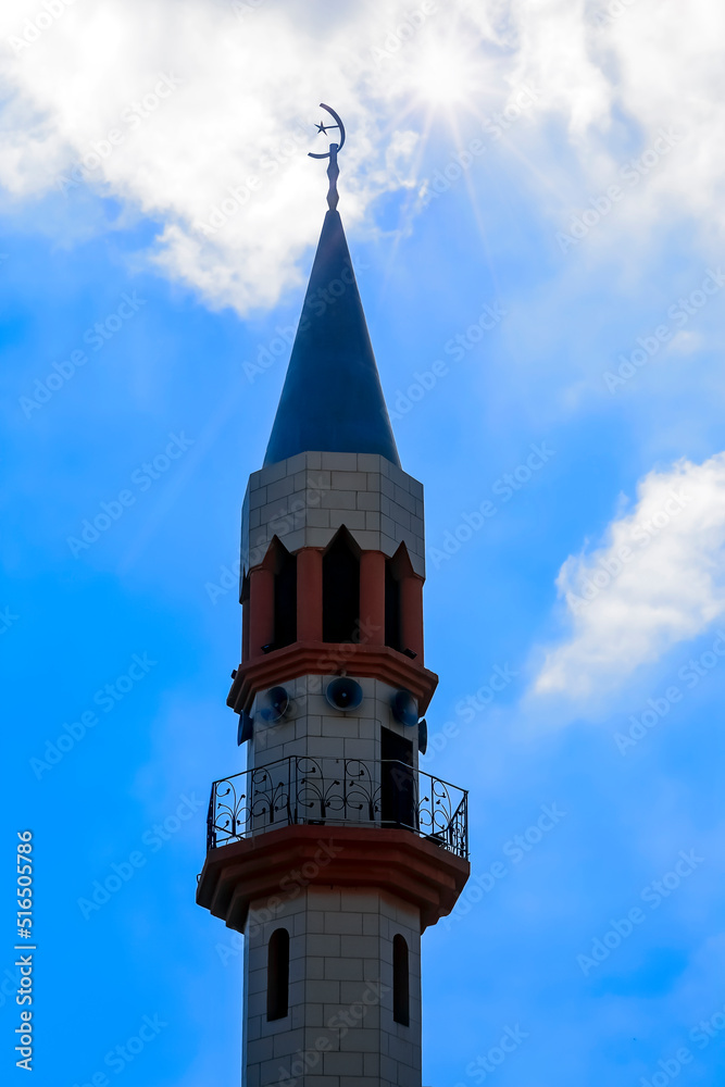 Ordinary modern mosque of muslim of city Tamra in Israel. Crescent on dome and minaret of mosque against blue sky. Symbol of Islam and Ramadan. Tourism, travel concept, islamic background. Copy space