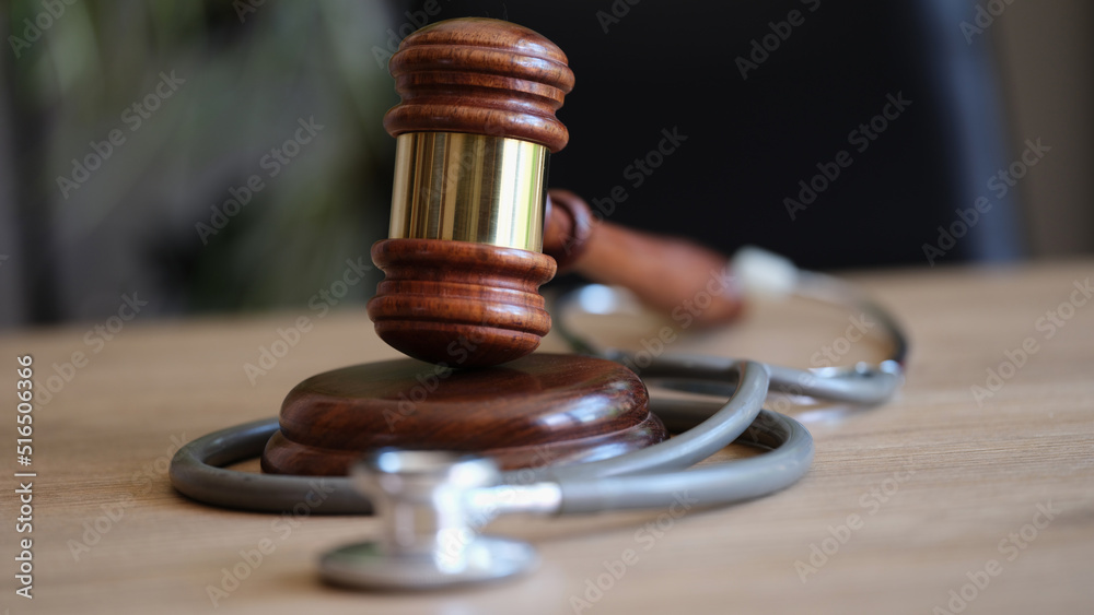 Judge gavel and medical stethoscope on office desk