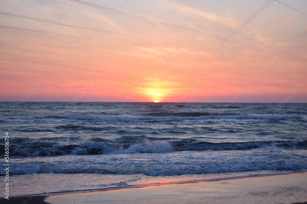 A beautiful sunset on the beach in the turbulent ocean A beautiful sunset on the beach in the turbulent ocean