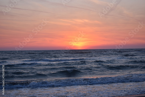 A beautiful sunset on the beach in the turbulent ocean © Artemisa