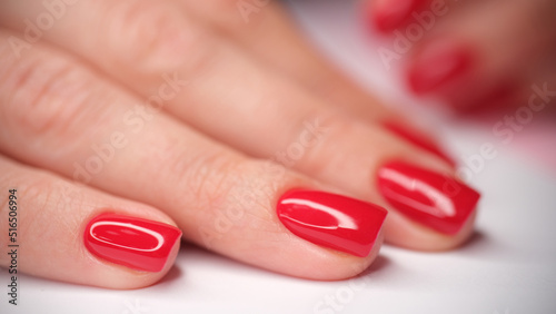 Female hands with stylish red glossy manicure photo