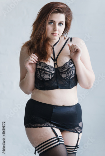 Cuadro en lienzo A plus size model in lacy black lingerie poses in a bright room with a trendy interior