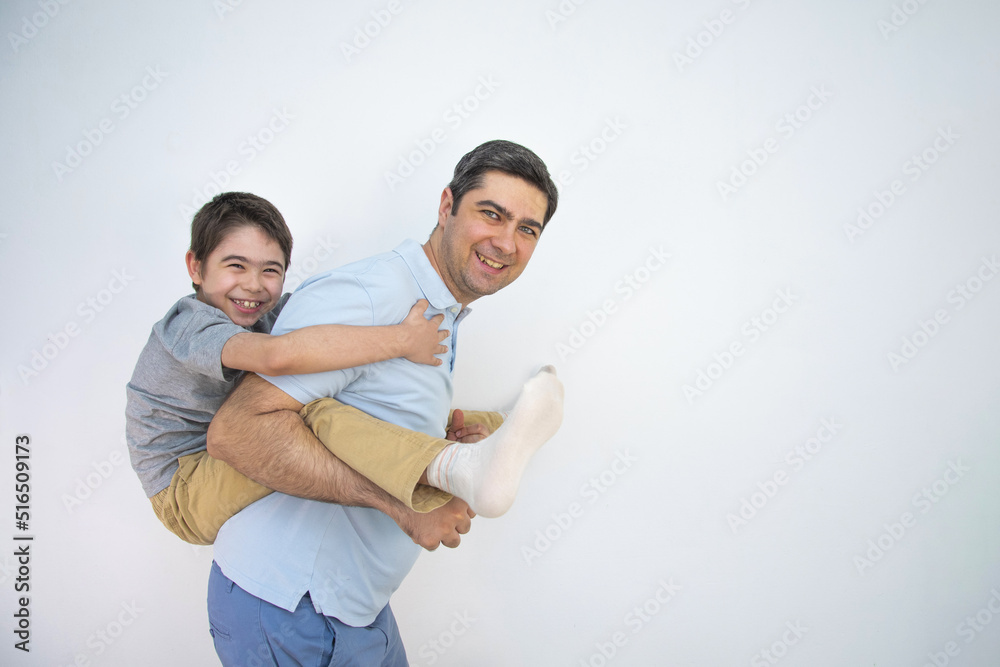 A man in a blue T-shirt sits on his back son