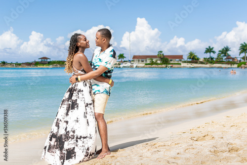 Young black couple look into each others eyes on the beach. Jamaican couple
