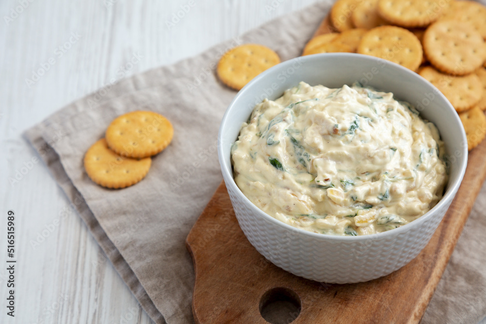 Homemade Caramelized Onion and Spinach Dip with Salty Round Crackers, side view. Homemade Caramelized Onion and Spinach Dip with Salty Round Crackers, side view.
