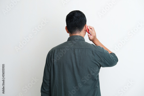 Back view of a man answering mobile phone call photo